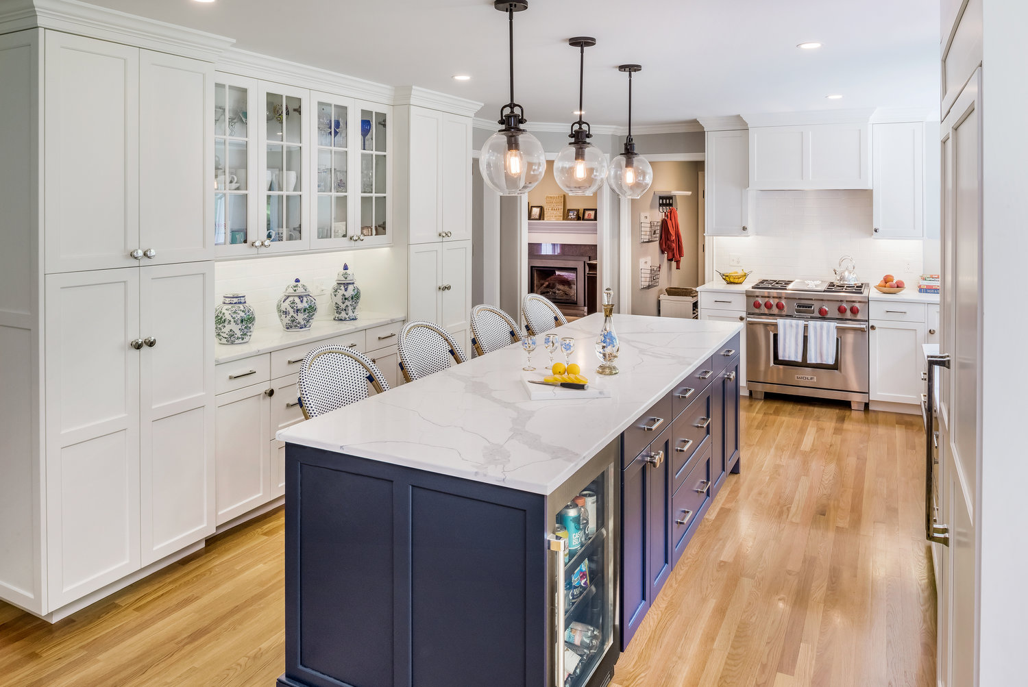 Example of using a pop of color strategically in a kitchen island – signature Cabinetry island in Navy Hale with perimeter cabinets in Colonial Simply White