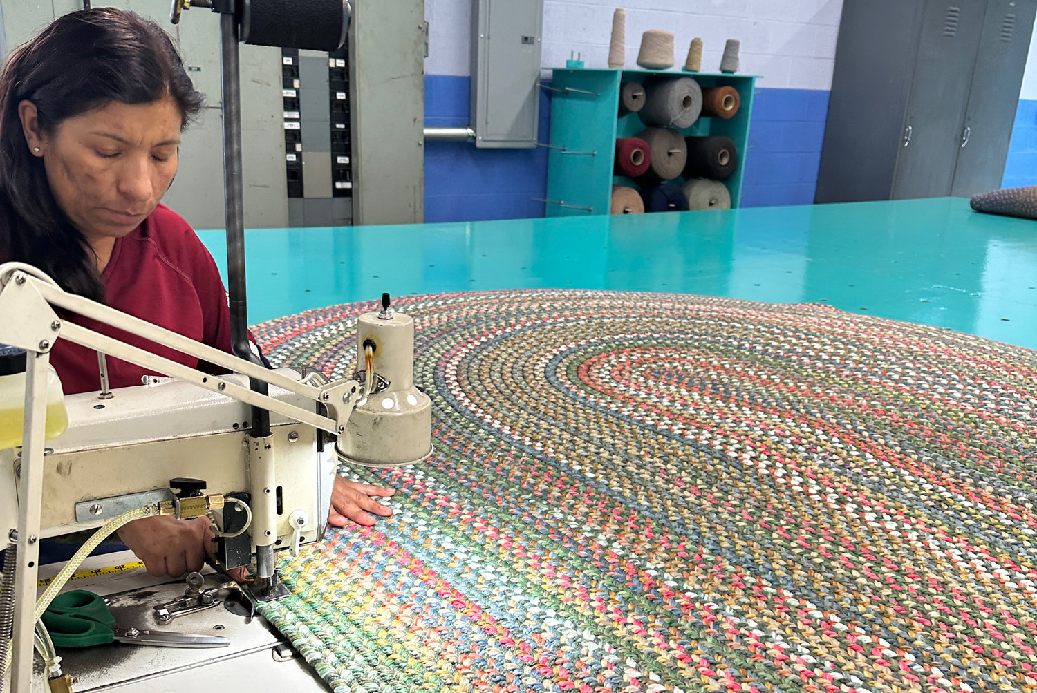 Teresa De Jesus Torres sews at the giant air hockey-like table
